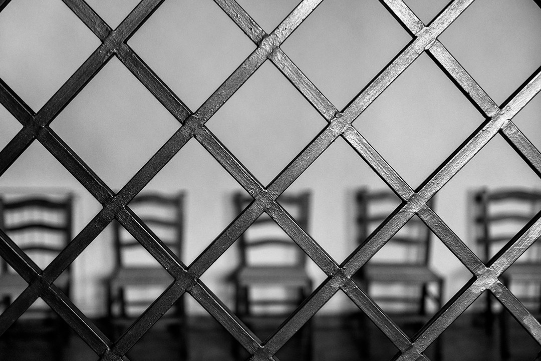 A convent room seen through an iron grille.
